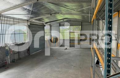 Hangar professionnel de 412 m² sur parcelle sécurisée, idéal pour activité ou stockage, avec deux accès portails et deux volets roulants.